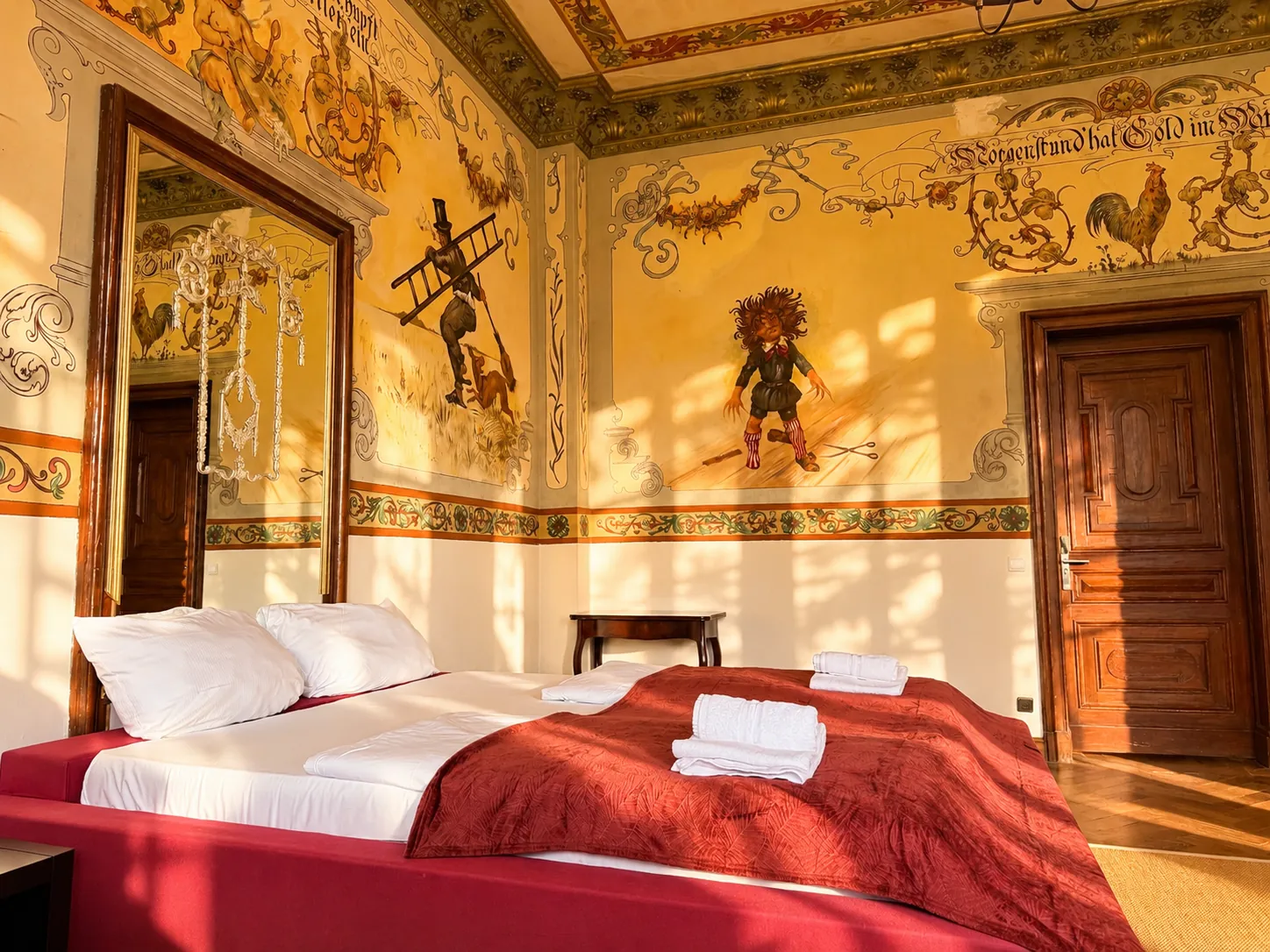 Bett mit Blick auf Wandmalereien und Spiegel