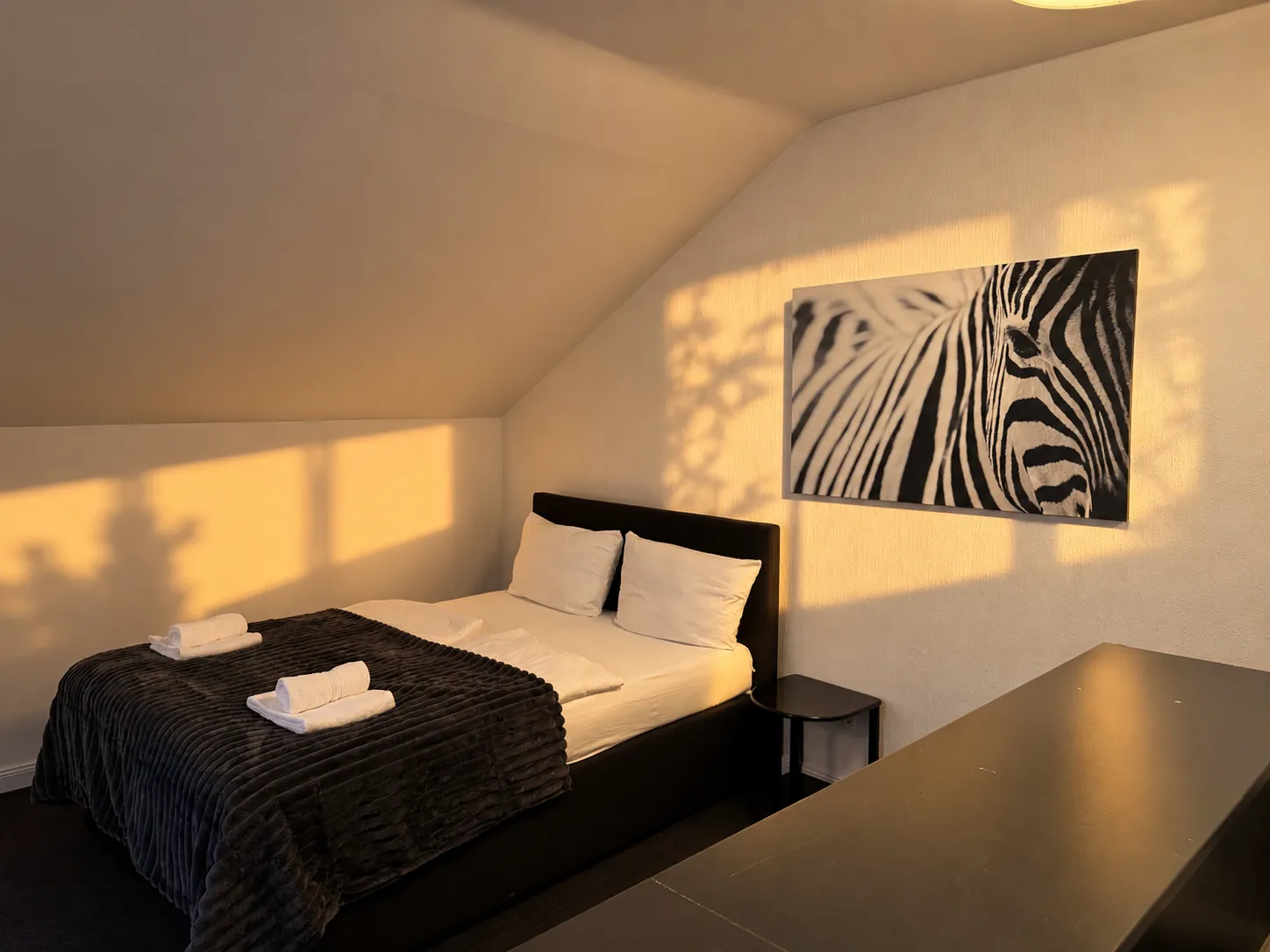 Doppelbett mit Wandbild im Abendlicht